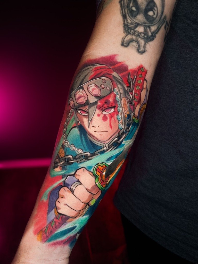 Tatuaje a color de Tengen Uzui de Demon Slayer en el antebrazo