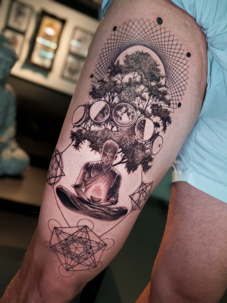 Tatuaje conceptual de monje meditando bajo árbol y fases de la luna en el muslo