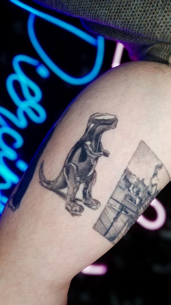 Tatuaje fine line de dinosaurio de juguete de plástico en sombras