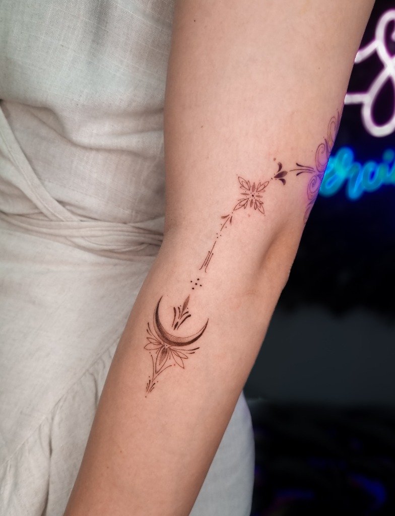 Tatuaje fine line geométrico con luna creciente y detalles estelares